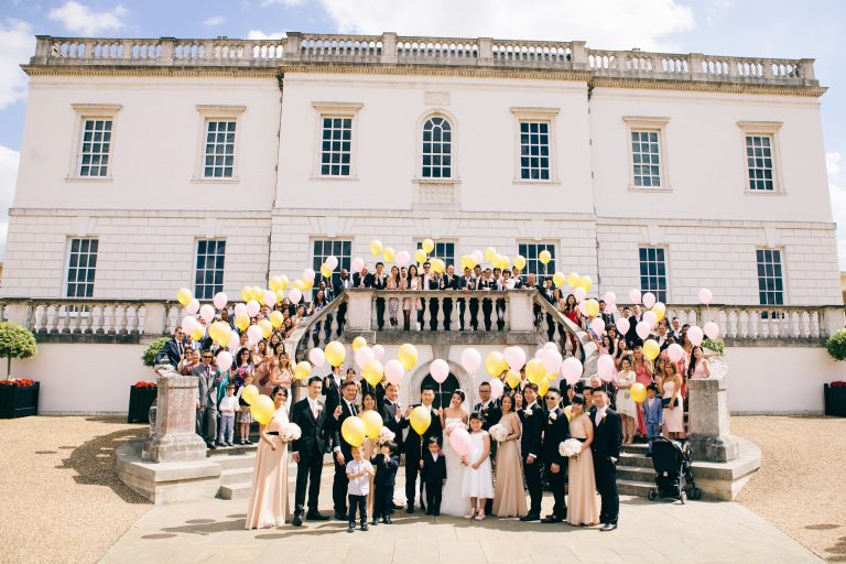 27 Queens House London 0064 SMP full wedding party with balloons front of house   full house in view te82az 768x512