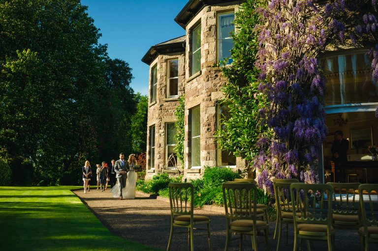 06870632 9862 4110 8d50 f7f3d4147f72 bride groom walking around the house outside 768x511