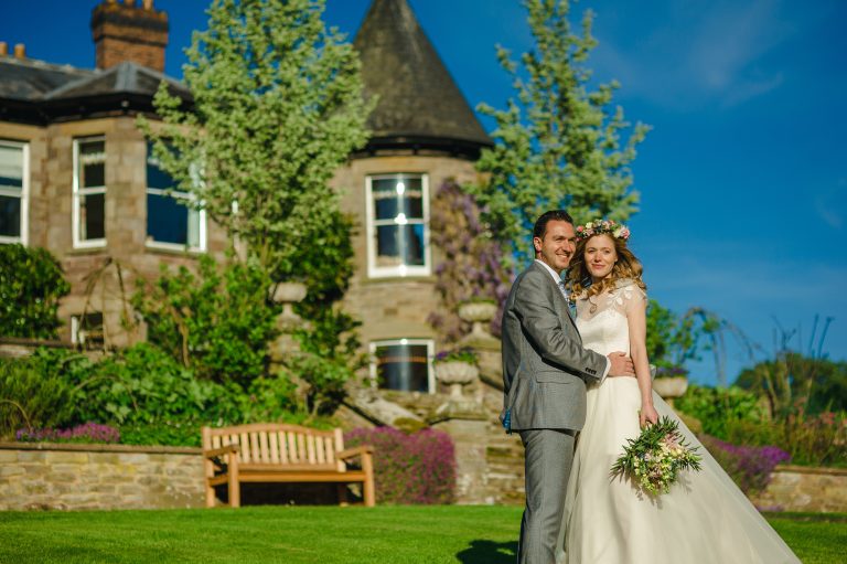 1ab64cc6 e1be 4de3 8165 1744b4363139 bride groom on lawn in front of house 768x511