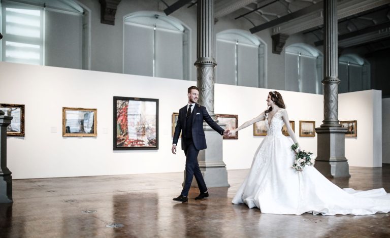 GroomholdingBrideshandWaterhall 768x469